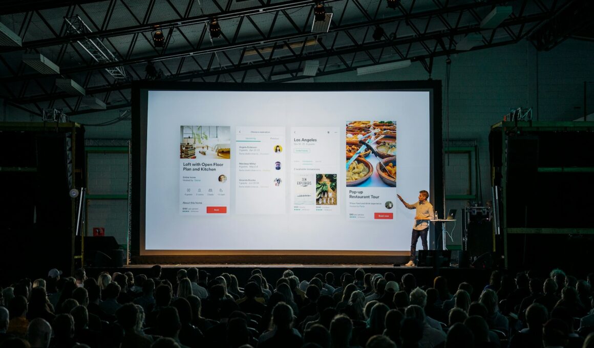 person discussing while standing in front of a large screen in front of people inside dim-lighted room